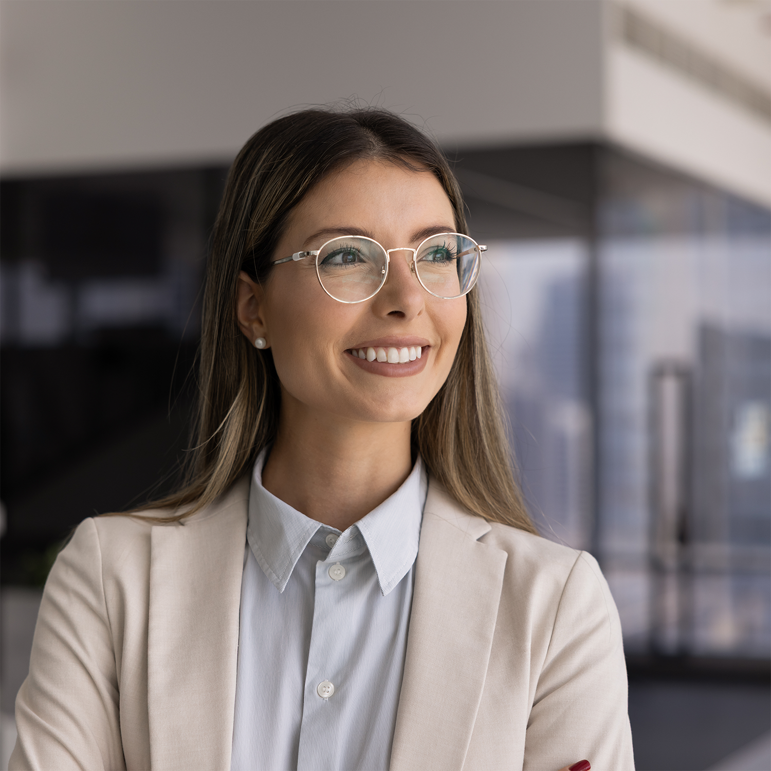 Woman wearing glasses and a beige blazer in an office setting